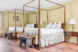 a bedroom with two beds with a four poster bed at Beekman Arms and Delamater Inn in Rhinebeck