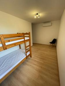 1 Schlafzimmer mit 2 Etagenbetten und Holzboden in der Unterkunft Le Clos des Cadots in Chaintré
