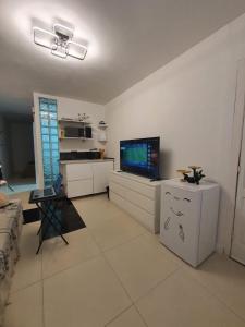 sala de estar con TV de pantalla plana y armarios blancos en Winnie's Homestay, en Las Palmas de Gran Canaria