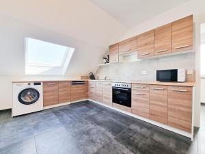 uma cozinha com armários de madeira e uma máquina de lavar e secar roupa em RAJ Living - 4 Room Apartments - 30 Min Messe DUS em Neuss
