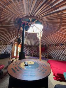 um quarto com um fogão numa tenda com tecto em Les songes du chêne em Augirein