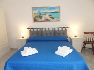 Un dormitorio con una cama azul con dos toallas encima. en Vincenzo Apartment, en Lampedusa
