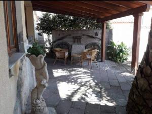 eine Terrasse mit einem Tisch und Stühlen unter einem Dach in der Unterkunft VILLA Casa MICHELA Pau in Pau