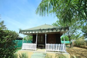 a small house with a porch and a white fence at Amrit Van Resort in Jaipur