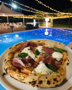 una pizza sentada en un plato junto a una piscina en Bla Bla B&B, en Taurianova