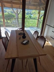 una mesa de madera con sillas en una habitación con ventana en Drinski merak, en Bajina Bašta