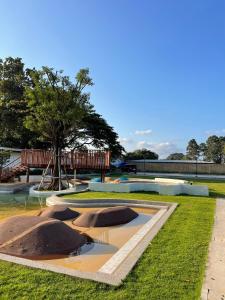 a park with a tree and a water fountain at The Season Rayong in Ban Chamrung