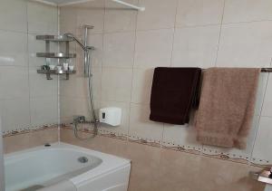 ein Bad mit einer Badewanne und 2 Handtüchern in der Unterkunft Family 2 bed Apartment in Bansko in Bansko