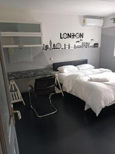 a bedroom with two beds and a chair in it at En-suite Soft Water Air Conditioning TV NEO in London