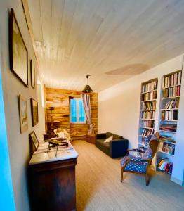 a living room with a couch and bookshelves at Gîte Béthel in Lachamp-Raphaël