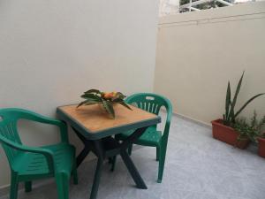 una mesa con dos sillas y una mesa con flores. en Vincenzo Apartment, en Lampedusa 16 fotos más