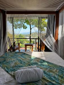 Cama en habitación con vistas en Villas In Sueño Private Jungle Hotel en Manuel Antonio