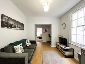 a living room with a couch and a tv at Suitely Stays Berkeley Apartment 2 in Cheltenham