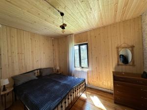 um quarto com uma cama e um tecto em madeira em Cozy Wooden House in Kiket'i კიკეთი em Kiketʼi