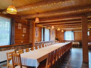 Una habitación grande con una mesa larga y sillas. en Neciunu sodyba, en Bijūnai