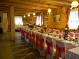 una mesa larga en una habitación con sillas rojas y blancas en Neciunu sodyba, en Bijūnai 37 fotos más