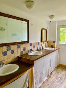 a bathroom with two sinks and a mirror at Gîte Béthel in Lachamp-Raphaël