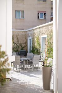 Royal Stay Luxury Homes في بافوس: فناء مع طاولة وكراسي ومبنى