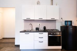 Mari Urbani في لا سبيتسيا: مطبخ بخزائن بيضاء وثلاجة سوداء