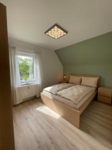 um quarto com uma cama grande e uma janela em Ferienwohnung zur Bitterbachschlucht em Lauf an der Pegnitz