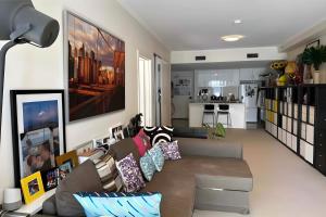 un soggiorno con divano e una cucina di 0 min to train, 2 stops to city a Sydney