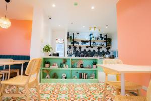 una habitación con mesas y sillas y una estantería verde. en JVJ HOTELS CORPORATION, en Batangas