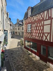 un callejón en una ciudad con un edificio rojo y blanco en L'Escapade Citadine, en Blois