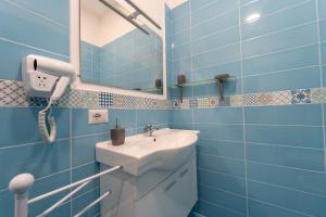 bagno blu con lavandino e specchio di Nientemale Residence Napoli a Pozzuoli