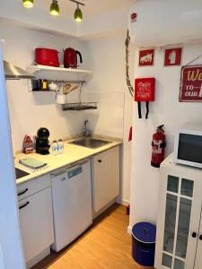 a small kitchen with a sink and a microwave at Casa Beco Do Castelo in Lisbon