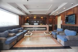 a living room with blue couches and a bar at اللؤلؤة الذهبي للشقق المخدومة in Al Madinah