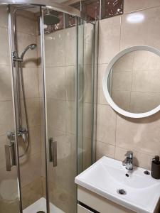ein Bad mit einer Dusche, einem Waschbecken und einem Spiegel in der Unterkunft Casa Beco Do Castelo in Lissabon