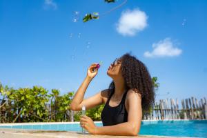 a woman flying a kite by a pool at Pili Pili Uhuru Beach Hotel in Jambiani