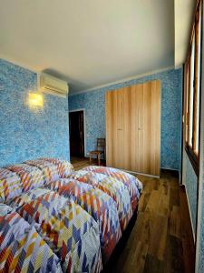 two beds in a room with blue walls at Guest House Fantaccini in Pelago