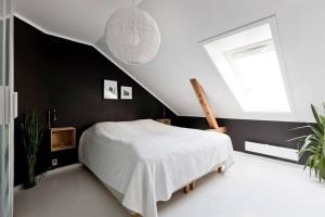 una camera con un letto bianco e una finestra di Large loft - Private rooftop terrace - Old Town a Oslo