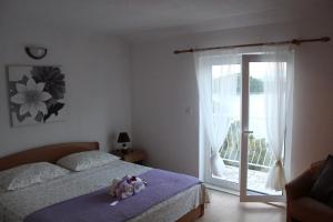 a bedroom with a bed with two stuffed animals on it at Apartmani Marija Mljet in Sobra