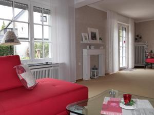 uma sala de estar com um sofá vermelho e uma mesa em Sommersonne em Warstein