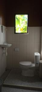 een badkamer met een toilet en een tv aan de muur bij Toraja Bungin Homestay in Rantepao
