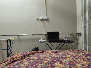 a bedroom with a bed with a laptop on a table at Pulai Homestay in Ipoh