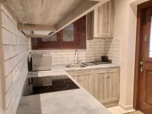 a small kitchen with a sink and a microwave at Τείχιο Πατρικό - Tihio Patriko - Πέτρινη κατοικία in Tíkhion +110 photos