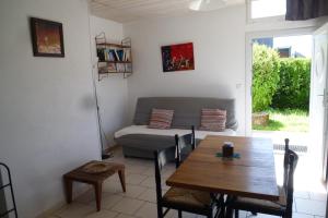 ein Wohnzimmer mit einem Tisch und einem Sofa in der Unterkunft Maison Ustou46 in Cahors