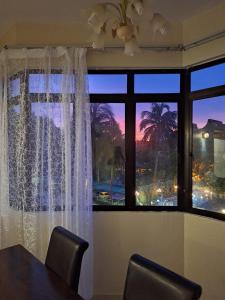 a room with a table and a window with a view at Seaput Srisayang in Batu Ferringhi
