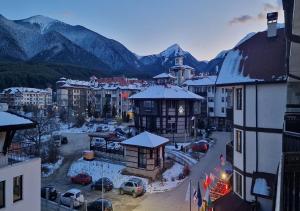 a small town with snow covered buildings and mountains at Family 2 bed Apartment in Bansko in Bansko