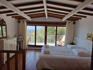 een slaapkamer met een groot bed en een groot raam bij Villa Clarté Sète in Sète