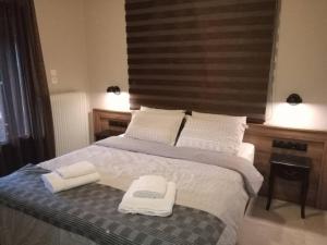 a bedroom with a bed with two towels on it at Τείχιο Πατρικό - Tihio Patriko - Πέτρινη κατοικία in Tíkhion