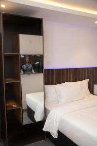 a woman taking a picture of a mirror in a bedroom at Baseville Hotel in Lagos