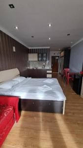 a bedroom with a large bed and a kitchen at Orbi Residence Volna,Batumi apart in Batumi