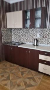 a kitchen with brown cabinets and a counter top at Orbi Residence Volna,Batumi apart in Batumi