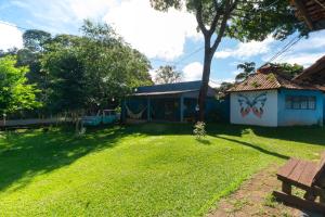 a yard with a building with a playground at Hostel e Camping Jardim da Mata in Chapada dos Guimarães
