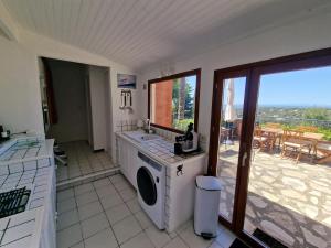 a kitchen with a washing machine and a balcony at Villa Clarté Sète in Sète