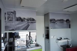 a kitchen with a sink and a view of a river at Houseboat Tiny Griffin in Nieuwpoort